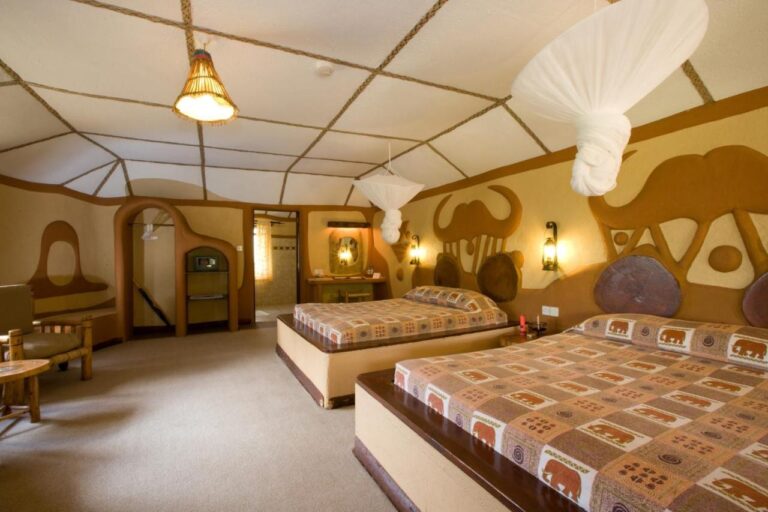 A twin room, with a buffalo head and an elephant carved in relief on the wall