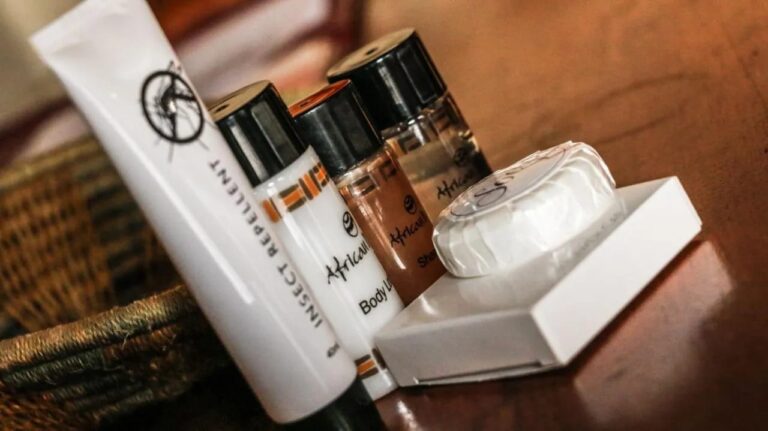 Guest toiletries on a wooden table: soap, body lotion and insect repellent
