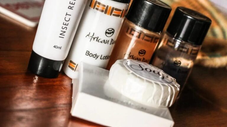 A bottle of insect repellent, a lotion and a wrapped soap, in close-up