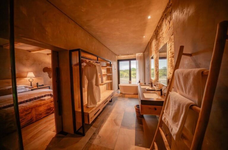 The passage to the bathroom of a suite, with a wardrobe, a double sink and a bathtub
