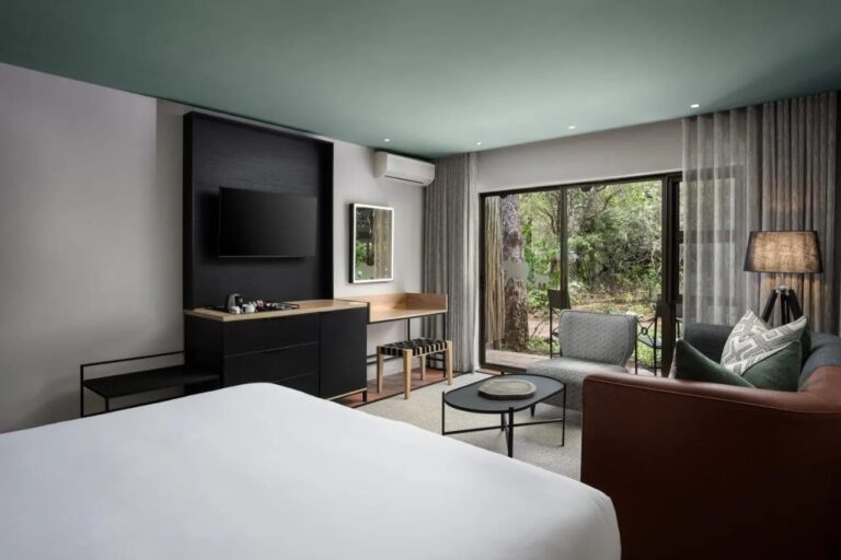 A Deluxe room opening onto the trees through a picture window