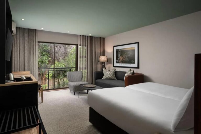 A Deluxe room with two twin beds and a view of the trees
