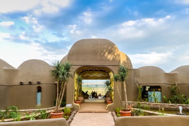 The entrance of the Mara Serena Safari Lodge, with its domed earth walls, opening onto the Masai Mara savanna