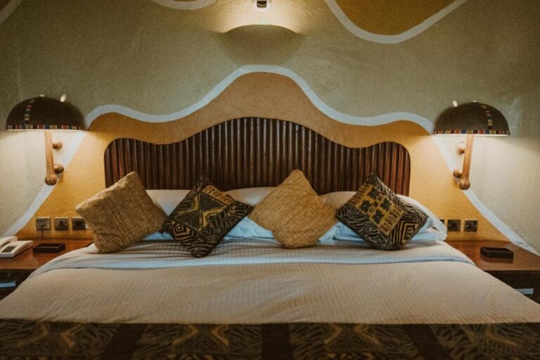 A wooden slat headboard between two mushroom-shaped wall lights