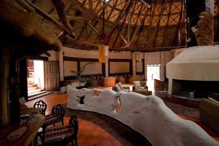A low white wall with sculpted shapes in the lounge, in front of the fireplace