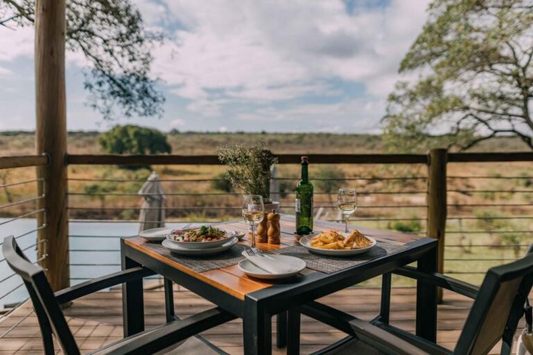 A meal served on a table on the wooden deck, facing the bush