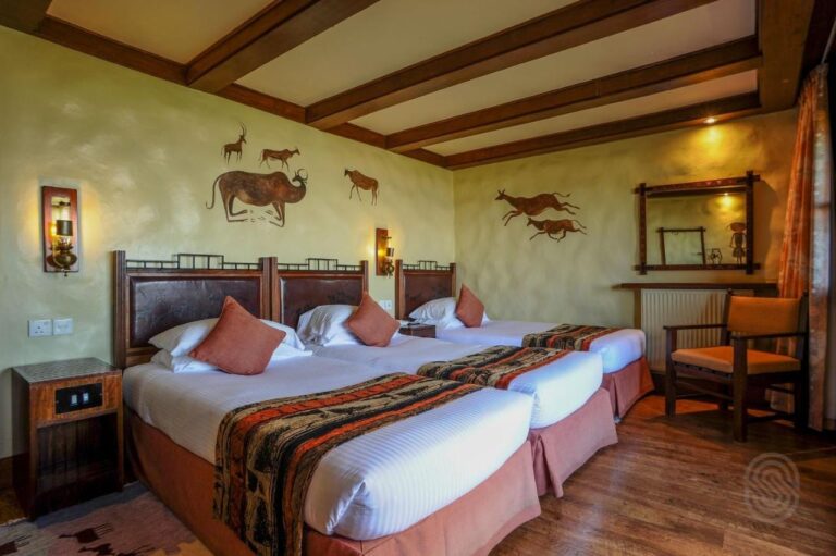 A triple room under wooden beams, with animals painted on the walls
