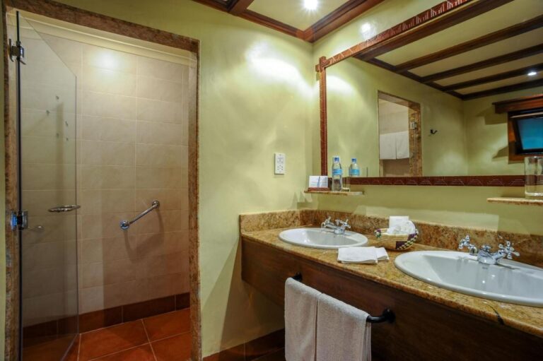 A bathroom with two sinks and a glass shower