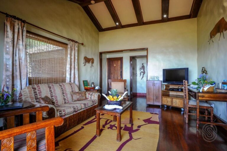 The living room of a suite, with a patterned sofa, a fruit basket and a TV