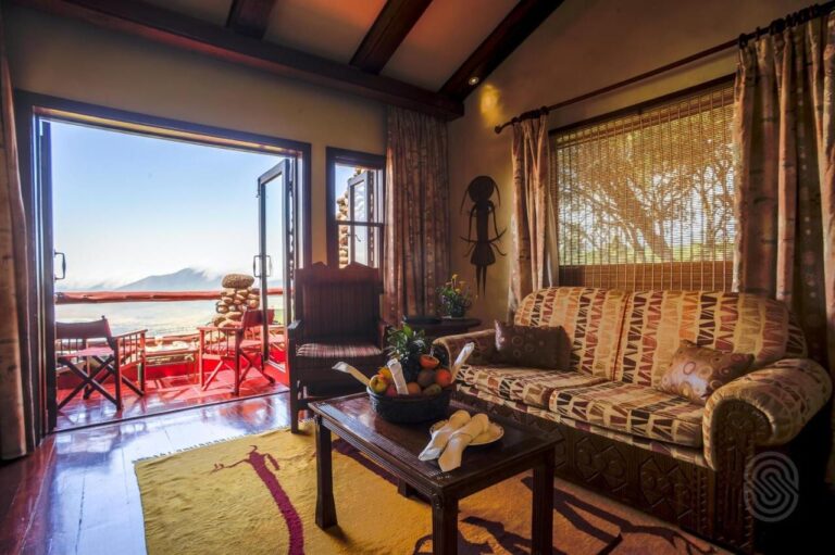 The living room of a suite opening onto a balcony, with a view of the crater