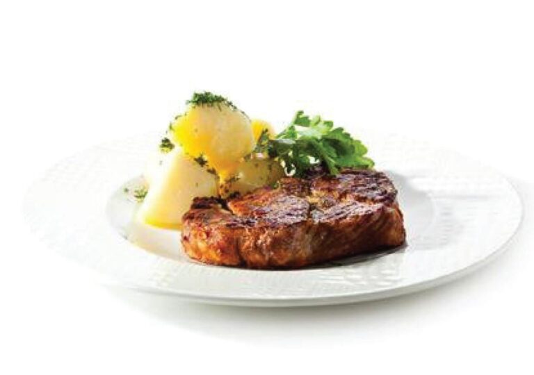 A piece of grilled meat with potatoes and herbs