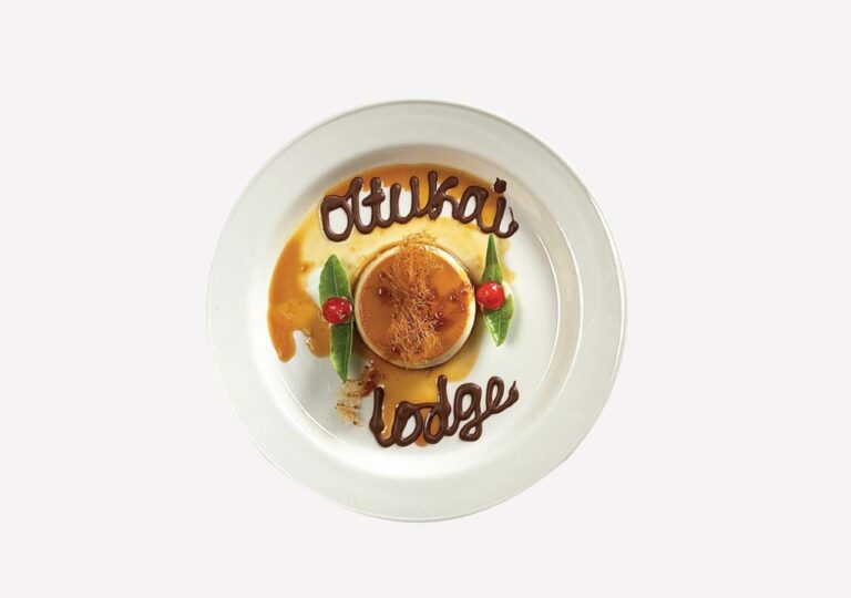 A caramel flan, with Ol Tukai Lodge written in chocolate on the plate