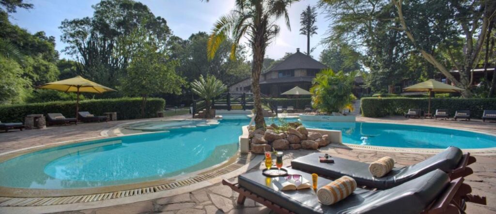 The lagoon-shaped pool at Sarova Mara Game Camp, around a rocky islet with a palm tree
