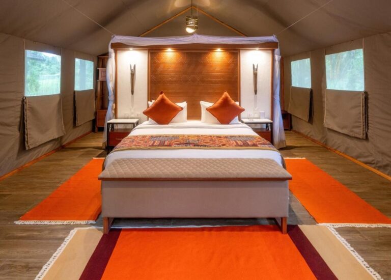 A large bed seen from the front, between two rows of canvas windows