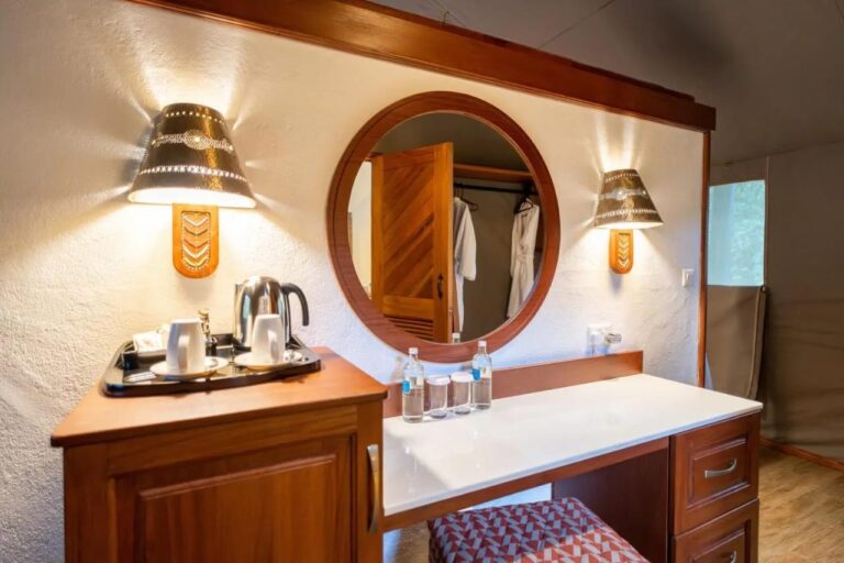 A dressing table with a round mirror, a tea tray and a kettle