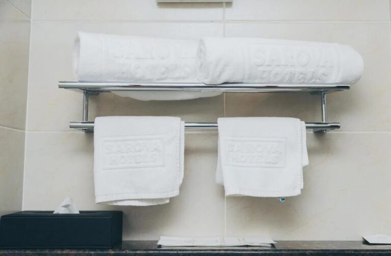 Towels marked with the Sarova Hotels name, on a towel rack