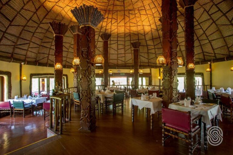 The restaurant under its dome, with wooden columns carved with figures and tables in white tablecloths