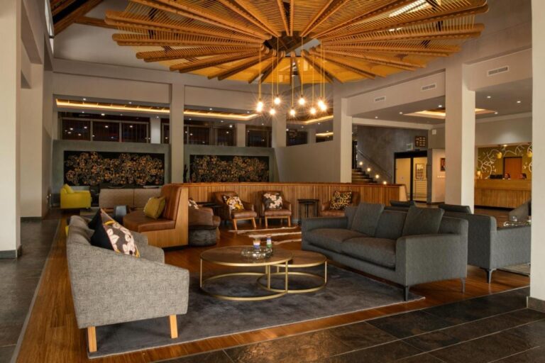 The lobby lounge, with gray sofas and leather armchairs, under a wooden slat ceiling