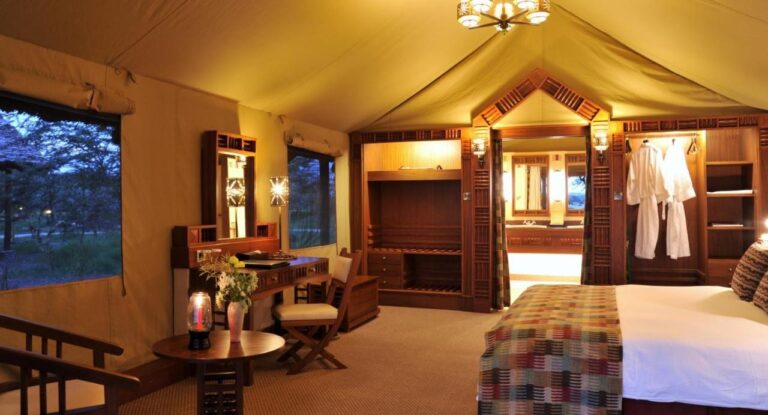 Inside a large tent, with a large bed, a dressing table and two bathrobes in the wardrobe