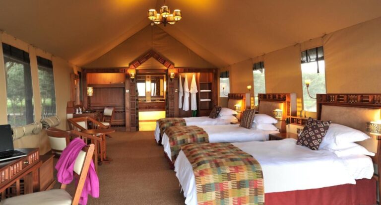 A large tent with three beds, a desk and three bathrobes in the wardrobe