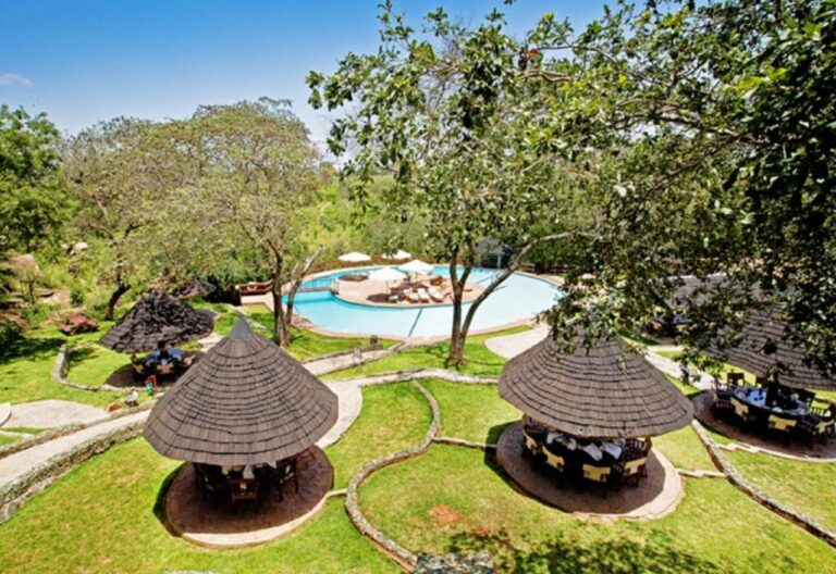 The pool at Tarangire Sopa Lodge and its thatched gazebos, among the trees