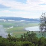 The green crater floor seen from the rim, with Lake Magadi and clouds clinging to the walls